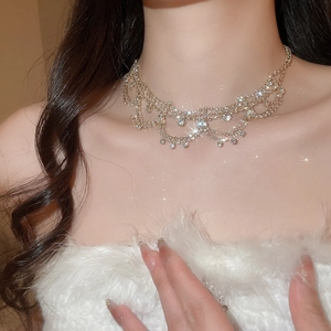 Close-up of luxury tiered gold necklace with sparkling rhinestones on elegant model