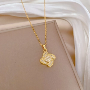 Detailed close-up of a gold clover pendant with sparkling zircon in a jewelry box