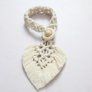 Detail of bohemian ivory cotton rope curtain tieback with leaf shape and wooden bead