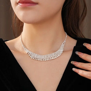 Detailed view of silver layered rhinestone tassel necklace on elegant black velvet dress