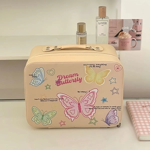 Détail de la trousse de maquillage beige avec des motifs colorés de papillons et cœurs