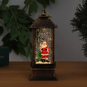 Close-up of vintage bronze Christmas lantern with Santa scene and swirling colorful glitter