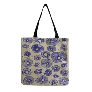 Detail of mushroom pattern print on durable beige linen tote bag with black handles