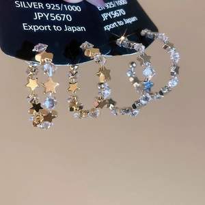 Macro shot of 925 silver hoop earrings with shimmering star-shaped cubic zirconia crystals