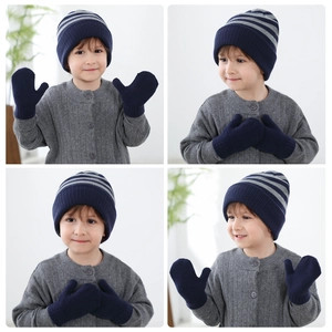 Detail of kids striped knit beanie and solid mittens with soft warm texture