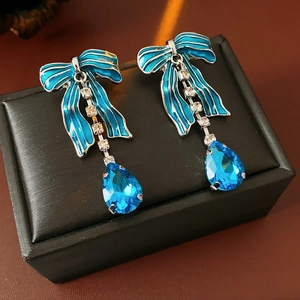 Dettaglio di orecchini a fiocco blu stile francese con cristalli e goccia elegante