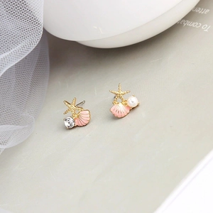 Makroaufnahme asymmetrischer rosa Seestern-Ohrstecker mit Perlen und Strass