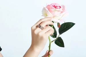 Detailansicht eines roségoldenen zweireihigen Kristallrings getragen von einem Model