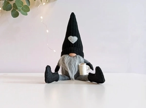 Détail d'un gnome de Noël tricoté tenant une tasse de café pour déco de fête