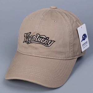 Detailed view of khaki cotton baseball cap featuring black Keeplucky embroidery and curved brim