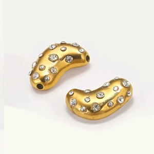 Detailed view of gold bean charms with pave-set crystals for DIY jewelry making