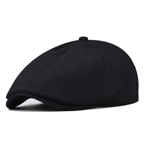Detailed side view of black cotton newsboy cap showing textured fabric and top button
