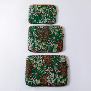 Three-piece set of green floral quilted laptop sleeves with daisy embroidery and zippers