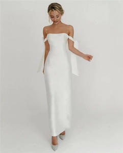 Elegant white satin wedding dress detail with strapless bodice and large ribbon bows