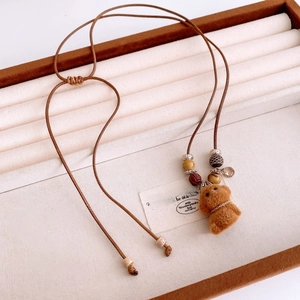Detail of flocking puppy pendant with wooden beads on brown wax cord necklace