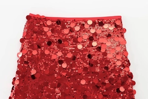 Close-up of vibrant red sequin A-line skirt featuring polished circular mirror sequins