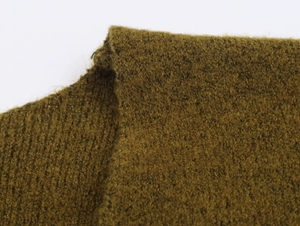 Gros plan sur un tricot marron olive montrant la texture douce et les coutures