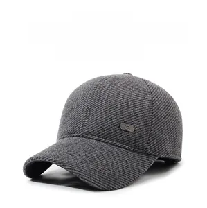 Detail of dark grey winter baseball cap with ear protection and metal logo accent