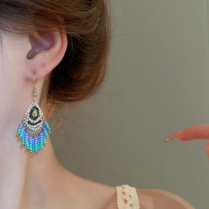 Detailed close-up of Bohemian tassel earrings with vintage beads on a model's ear