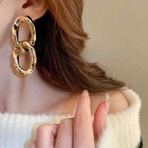 Gros plan de boucles d'oreilles chaînes dorées avec une finition métallique polie élégante