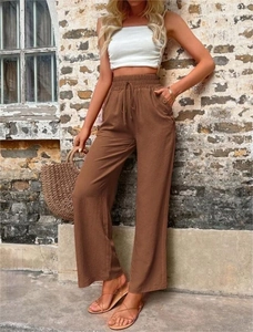 Détail de la taille haute à cordon et texture coton-lin sur un pantalon large brun