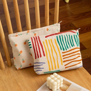 Close-up of floral and striped corduroy cosmetic bags with metal zipper details