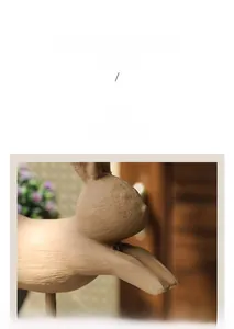 Détail de la texture en bois sculpté et des lignes fluides de cette figurine de lapin