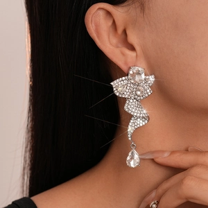 Close-up of sparkling silver drop earrings with pavé crystals and pear-cut stone