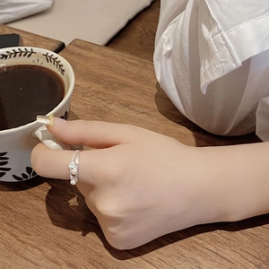 S925 sterling silver shell ring with freshwater pearls worn while holding a coffee cup