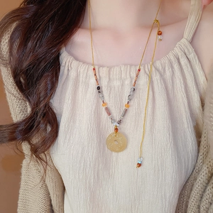 Détail du collier ethnique en agate grise avec pendentif évidé et décor de pompons