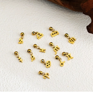 Macro shot of twelve golden 18K stainless steel zodiac charms for DIY jewelry making