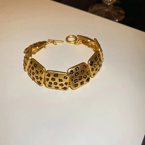Details eines Vintage-Armbands mit Leopardenmuster und elegantem Gold-T-Verschluss