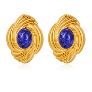 Macro shot of gold swirl earrings featuring an oval blue stone with natural texture