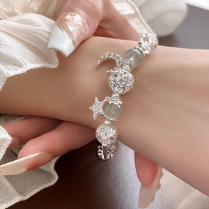 Close-up of star and moon bracelet with zircon beads and silver charms on wrist