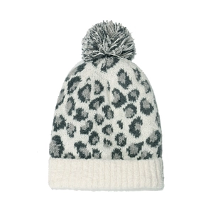 Détail d'un bonnet en tricot léopard avec un pompon duveteux et un revers côtelé