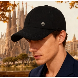 Detail of black men's baseball cap with silver 'FASHION' metal badge on the side