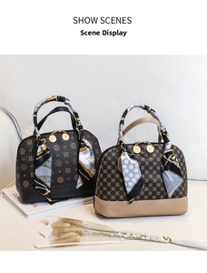 Detail of classic patterned shell bag with decorative scarf and golden hardware accents
