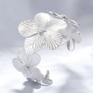 Macro shot of silver metal flower petals on an open bracelet with detailed texture