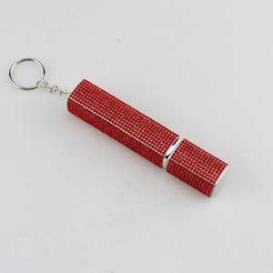 Detailed view of red rhinestone-encrusted lipstick tube keychain with silver metal ring