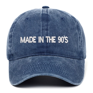 Close-up of 'MADE IN THE 90'S' white embroidery on washed navy cotton baseball cap