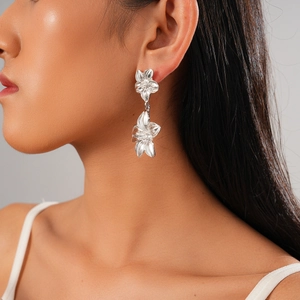 Macro view of silver floral drop earrings with polished metallic petal texture