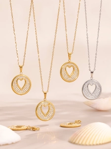 Detalle macro de colgantes de corazón hueco en oro y plata con circonitas brillantes