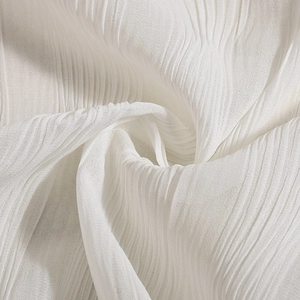 Macro shot of white pleated fabric texture with sheer lightweight material and soft folds