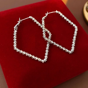 Textured silver heart earrings displayed on a premium red velvet jewelry box