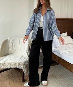 Chemise polo à rayures bleues associée à un pantalon large noir à taille haute élégant