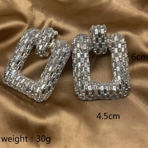 Detailed view of oversized chain earrings with sparkling rhinestones, 6cm by 4.5cm size