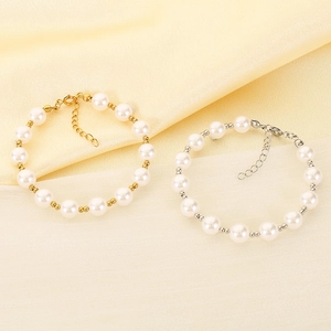 Close-up of elegant pearl bracelets with gold and silver finishes on satin background
