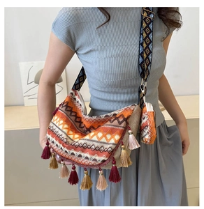 Detail of bohemian tote with ethnic embroidery, fringe tassels and wide strap