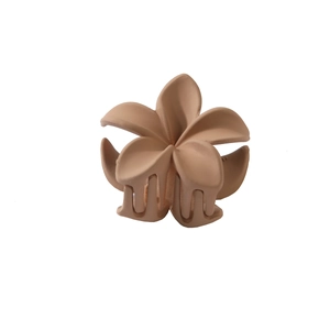 Macro shot of matte nude frangipani flower hair claw clip with detailed sturdy grip teeth