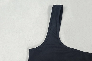 Detailed view of the double stitching on the shoulder straps of a black bodysuit